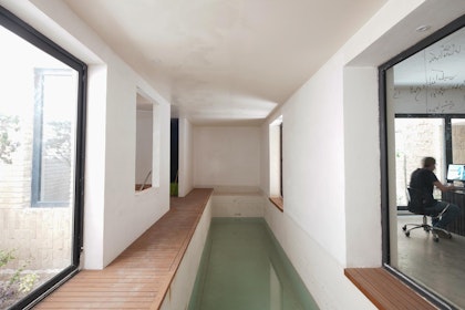 A narrow indoor pool on the basement floor adjoining a courtyard (left) and a living/working space (right). | Aga Khan Trust for Culture / Deed Studio (photographer)