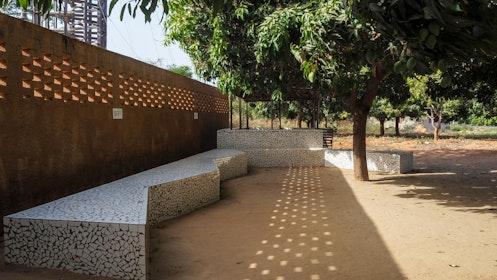 Outdoor seating shaded by a large tree. | Aga Khan Trust for Culture / Amir Anoushfar (photographer)