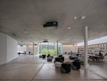 The “Launch Pad” is a community space that fulfils cultural and social functions with multiple programmes and activities. It fans around the Saucer's faceted retaining walls (here on the left). Along the library wall, long tables and chairs double as working and workshop spaces. | Aga Khan Trust for Culture / Danko Stjepanovic (photographer)