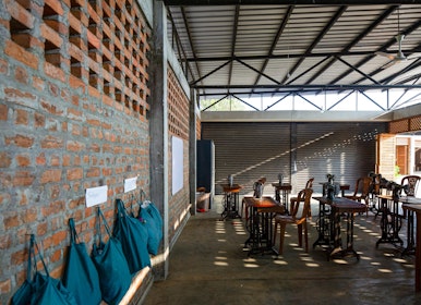 The perforated brick walls maximise airflow and the raised aluminium roofs partially reflect the solar heat owing to a Low-E coating, keeping the interiors cool. | Aga Khan Trust for Culture / Nipun Prabhakar (photographer)
