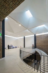 The white concrete staircase ascends through a double-height space and lands in a tall gallery. | Aga Khan Trust for Culture / Deed Studio (photographer)
