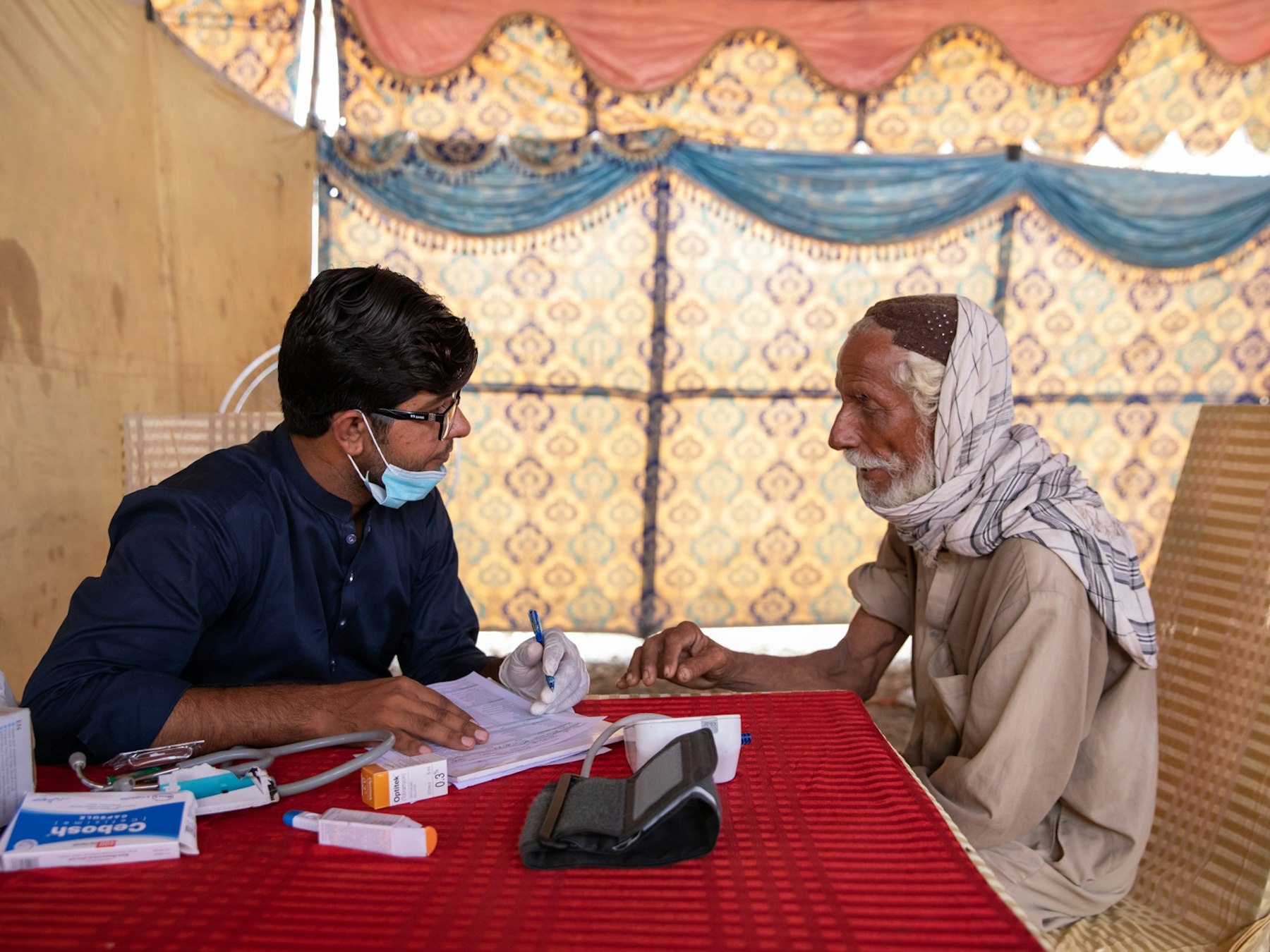 An elderly man gets assessed for iron deficiency, fever and cough inside an AKU healthcare camp in Dadu District on 26 September 2022. Photo credit: AKDN / Insiya Syed